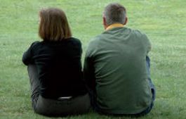 Adams Harrison Family Law picture Older couple sitting on grass, enjoying peaceful outdoors, representing estate planning and legal services.